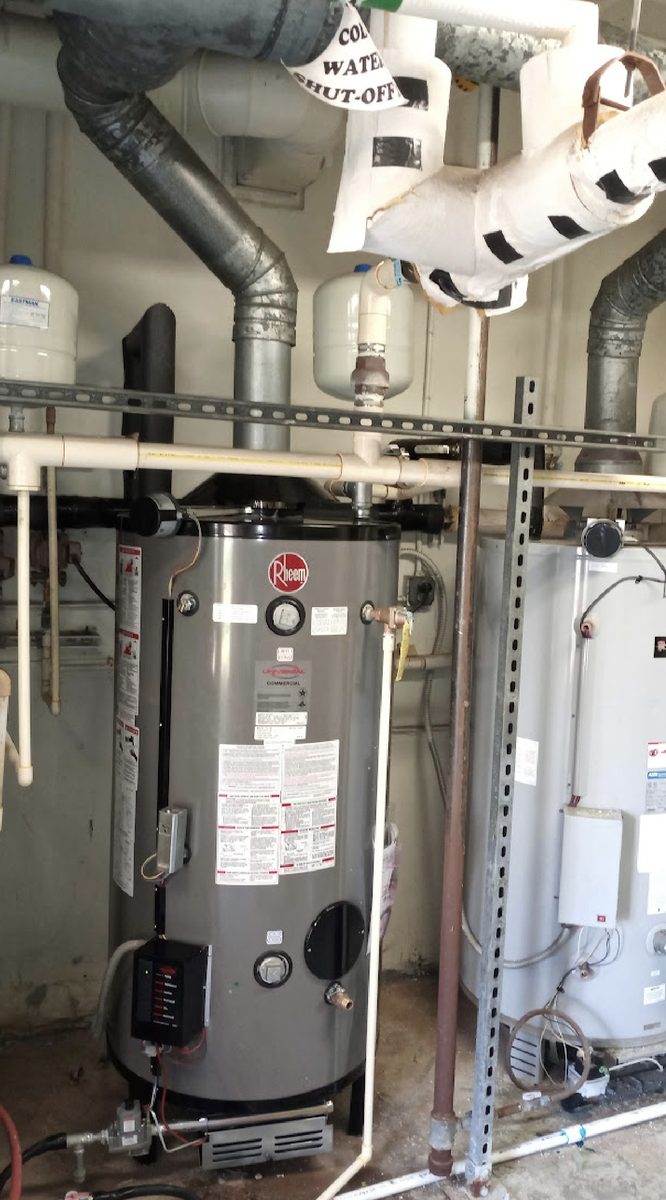 Commercial boiler replacement with gas piping, expansion tanks and flue connections in a mechanical room