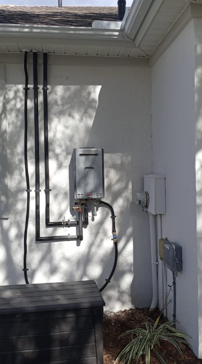 Rinnai tankless water heater mounted on an exterior wall with new gas line and isolation valves